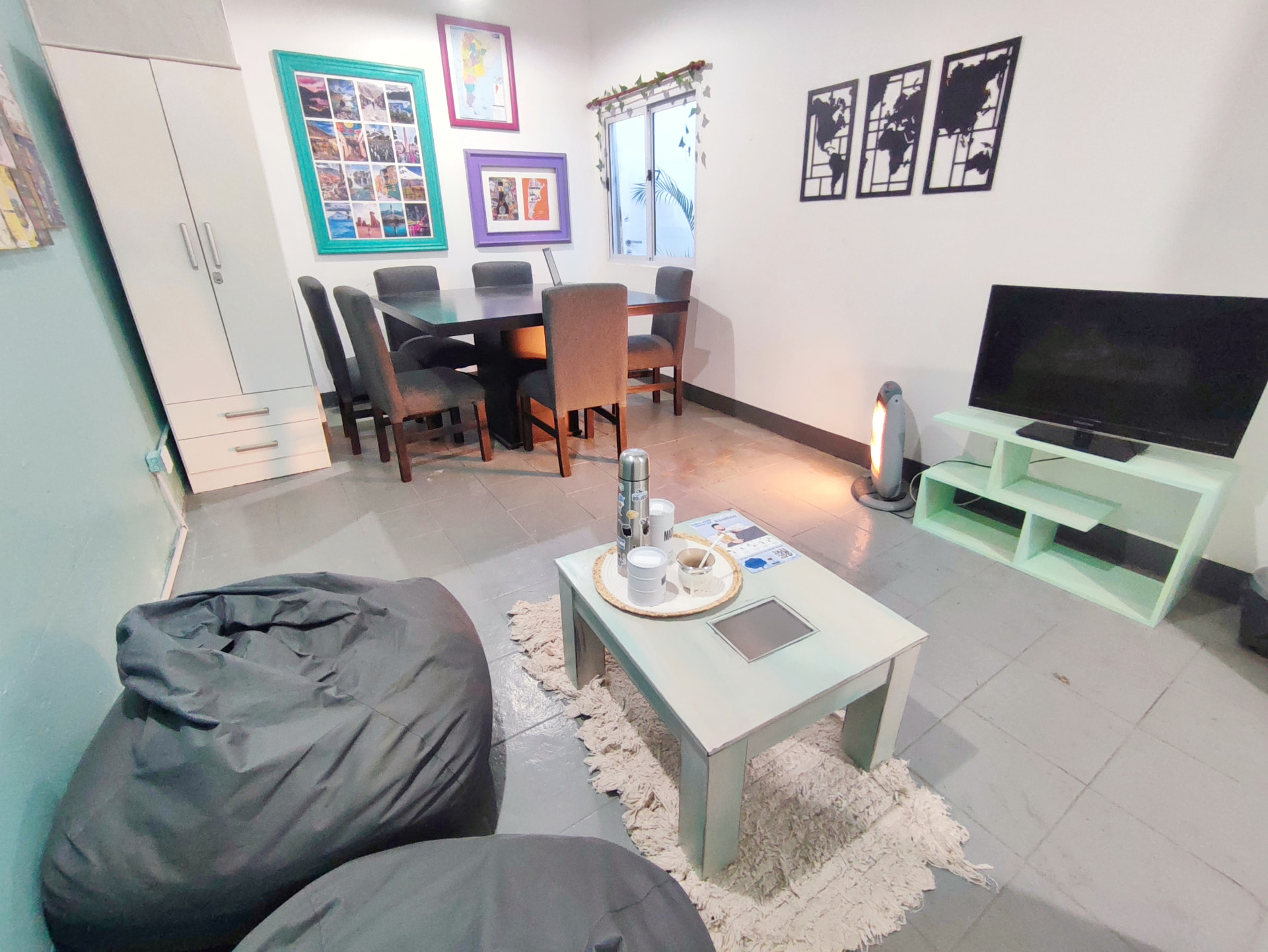 Living room and dining room of Casa Tango with TV, bean bags and travel photos on the walls