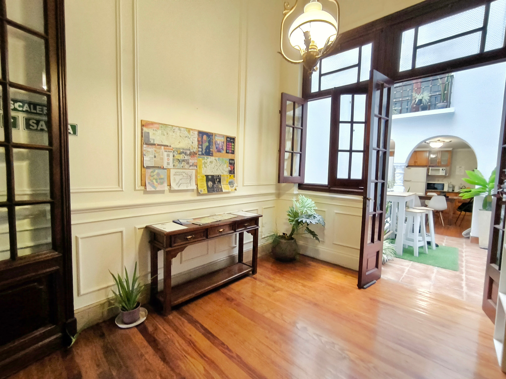 Entrance hall of Casa Jacarandá with wooden floor, classic panelled walls and French doors to the patio