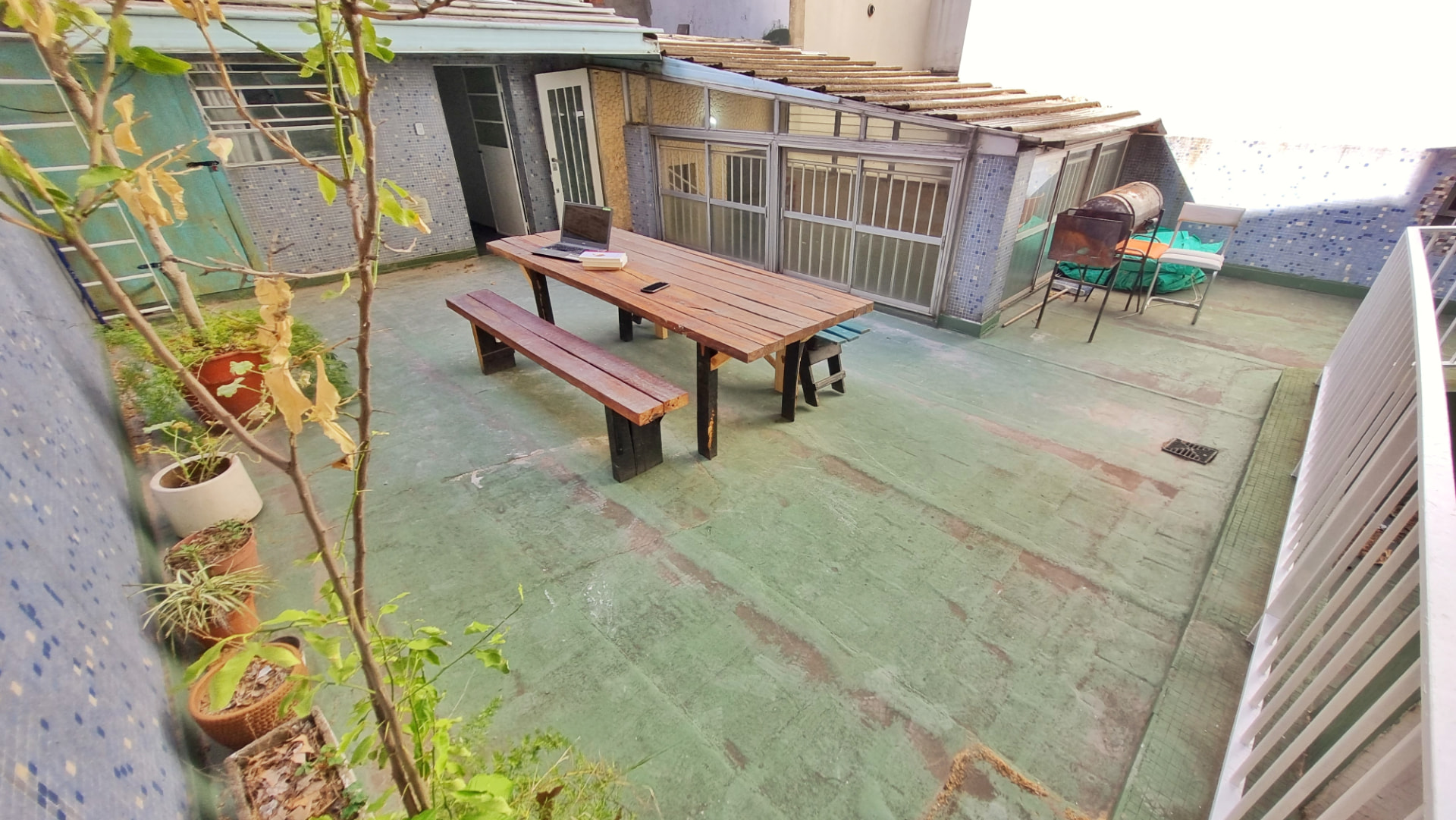 Terrace of Casa Patio with a long wooden table and benches next to the winter garden
