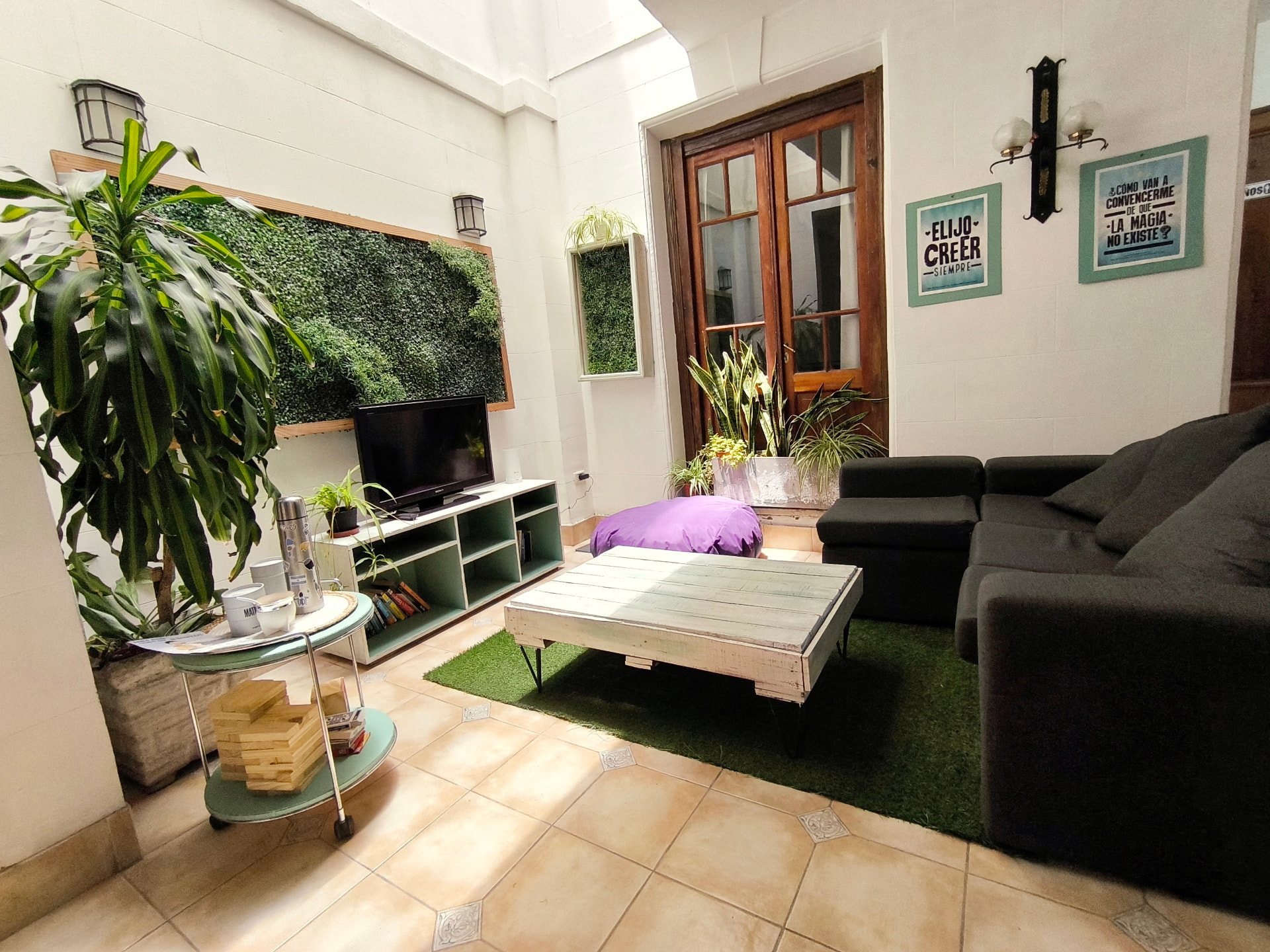 Living room of Casa Jacarandá with a vertical garden wall, TV, sofa and mate set